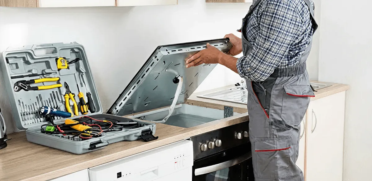 Handyman repairing a cooktop and checking wiring connections in Erie, PA